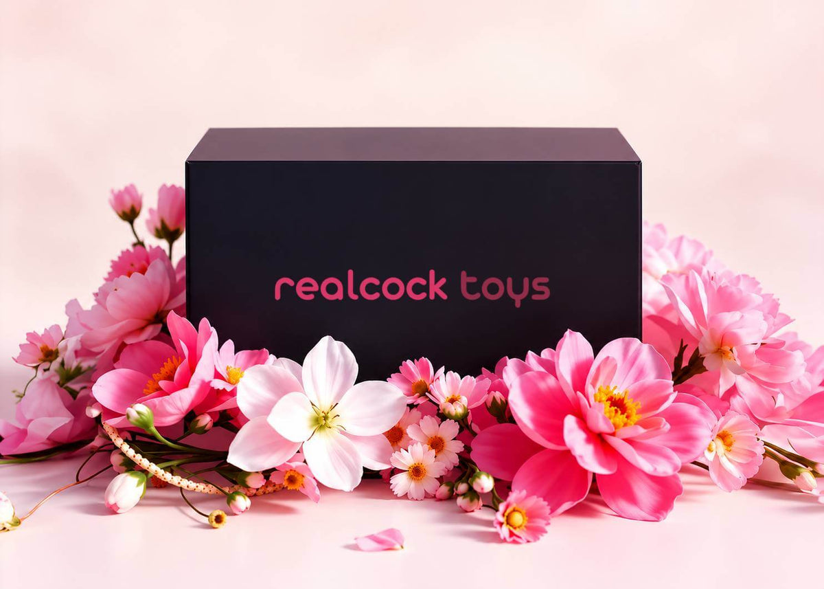 RealCock Toys discreet black gift box surrounded by pink flowers