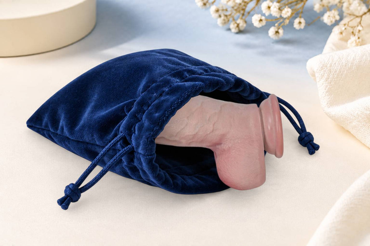 Realistic silicone dildo stored in a navy Velvet Toy Pouch with drawstring closure